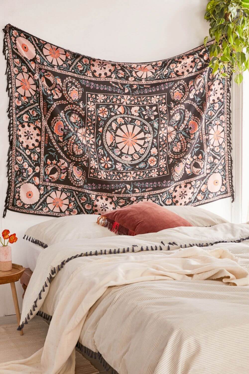 floral tapestry with striped blanket and hanging plant